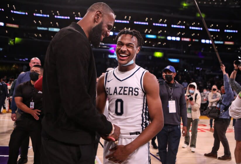 LOS ANGELES, CA - DECEMBER 04: Lebron James comes onto the court to congratulate his son Bronny James (0) point guard for Sierra Canyon after his team won against St. Vincent-St. Mary during "The Chosen - 1's Invitational High School Basketball Showcase" at the Staples Center on Saturday, Dec. 4, 2021 in Los Angeles, CA. (Jason Armond / Los Angeles Times)