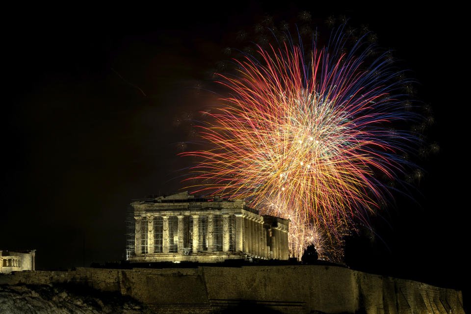 Fuegos artificiales explotan sobre el Partenón, en la Acrópolis, durante la celebración del año nuevo, en Atenas, Grecia, el 1 de enero de 2024. (AP Foto/Yorgos Karahalis)
