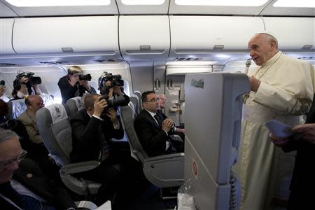 Pope Francis (R) talks to journalists aboard the papal flight on his way to Amman, May 24, 2014. REUTERS/Andrew Medichini/Pool