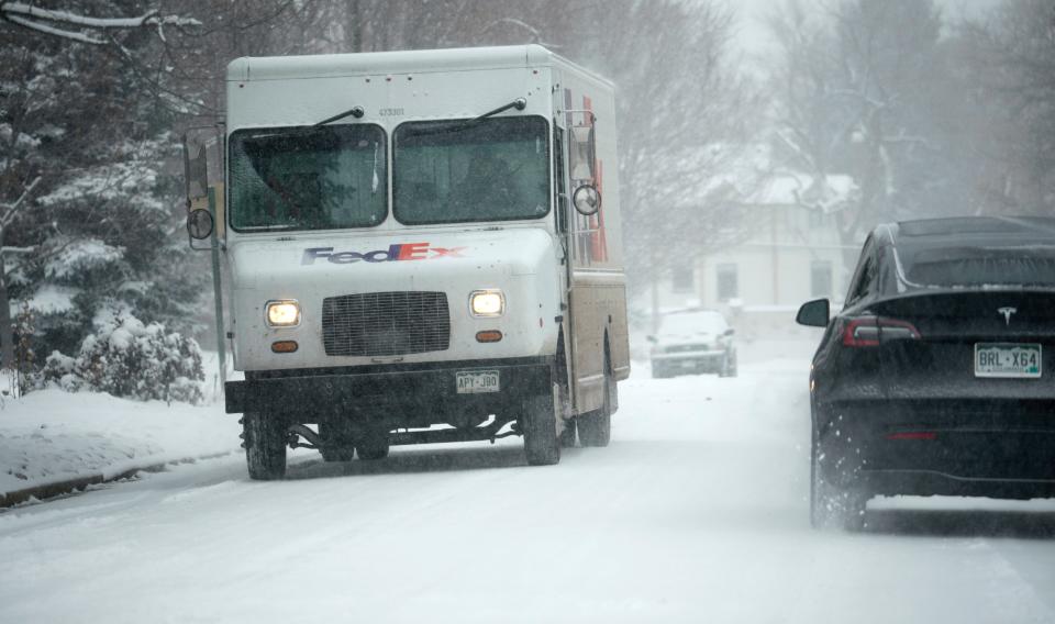 A FedEx delivery vehicle moves along South Monroe Street after a winter storm packing single-digit temperatures combined with a light snow crossed over the intermountain West Wednesday, Feb. 15, 2023, in Denver. Forecasters predict that the frigid temperatures and snow will move out of the region by Thursday.