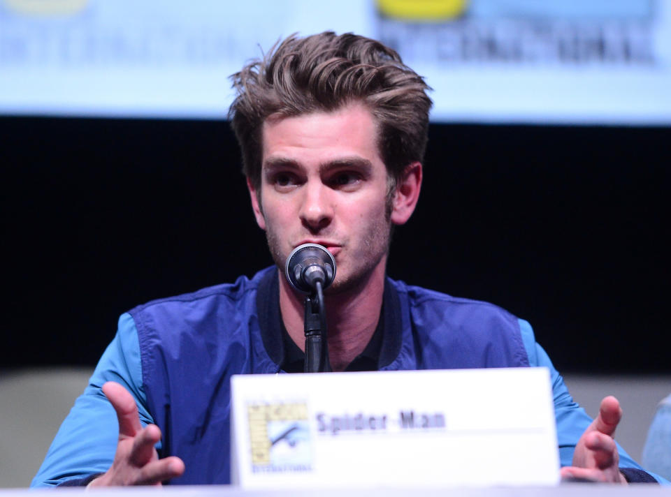 Close-up of Andrew at a press conference sitting in front of a microphone