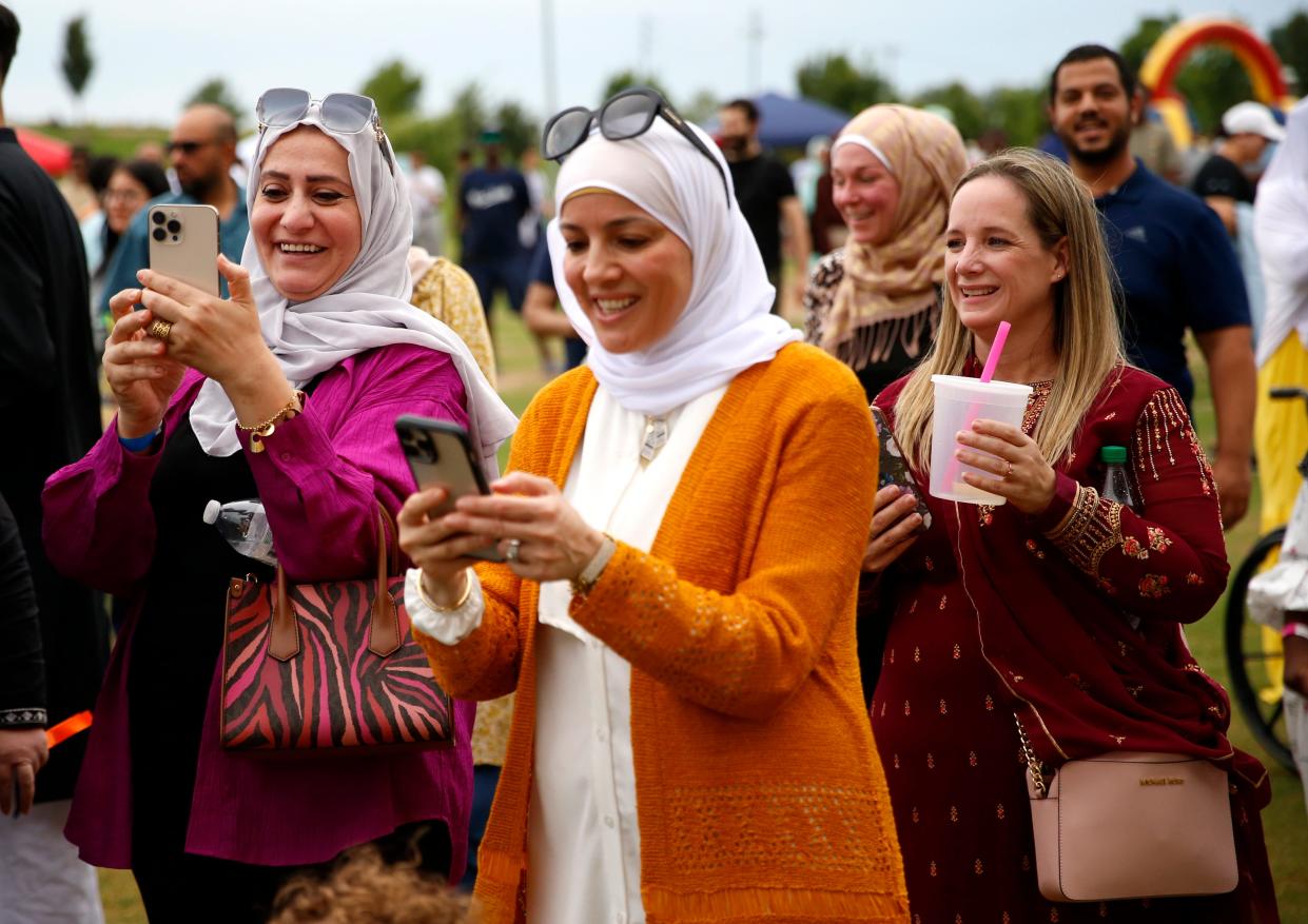 People take photos of the dunk tank activities at the 2023 United Eid Festival celebrating Eid al-Adha at Scissortail Park in Oklahoma City.