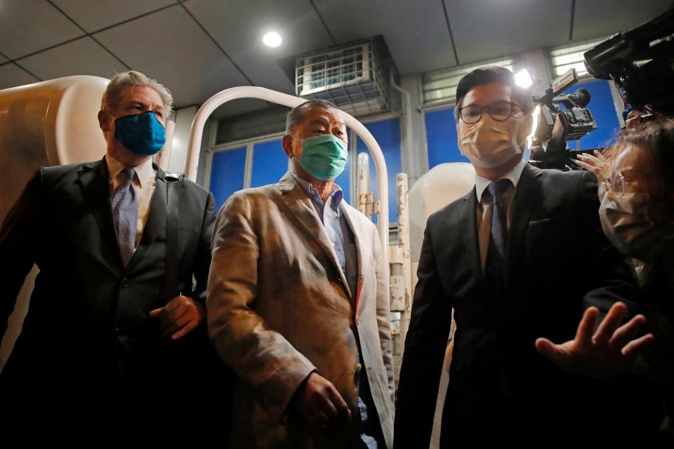 Media tycoon and newspaper founder Jimmy Lai, center, leaves a police station in Hong Kong on Aug. 12, 2020.