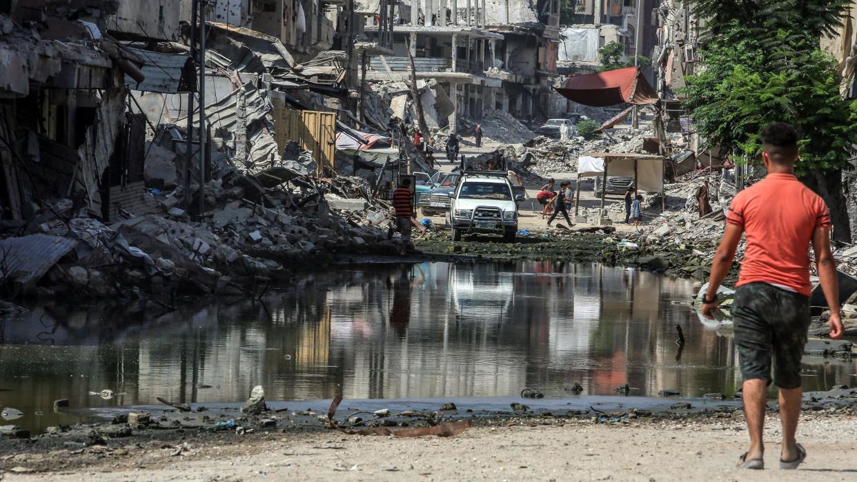 A Palestinian man walks towards a pool of water in Gaza