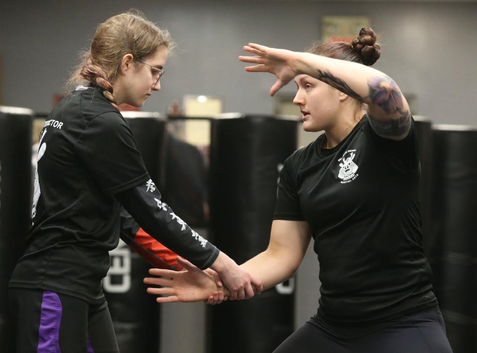 Instructors Aliyah Friend, left, and Rebecca Evans demonstrate self-defense techniques for Girls Unite for Defense members at Delaware Dragon Martial Arts in Newark.