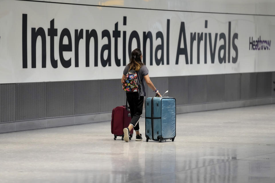 FILE - A passenger arrives from a flight at Terminal 5 of Heathrow Airport in London, Monday, Aug. 2, 2021. Vaccinated travelers can now enter Britain without taking any coronavirus tests. Starting Friday, Feb. 11, 2022 British residents and visitors who have had at least two doses of a coronavirus vaccine now only need to fill out a passenger locator form before traveling to the U.K. (AP Photo/Matt Dunham, File)