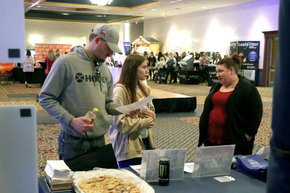 Landon Brown and Gracie Gill visit with Taryn West about wedding services at the 2023 Amarillo Bridal Show held at the Amarillo Civic Center Sunday afternoon.