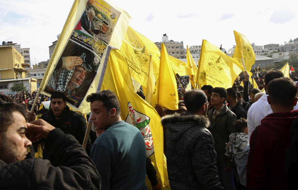 Palestinian supporters chant slogans and wave yellow Fatah flags and portraits of the late Palestinian President Yasser Arafat during a celebration marking the 55th anniversary of the Fatah movement, in Gaza City, Wednesday, Jan. 1, 2020. Tens of thousands of Palestinians took to the streets in Gaza Wednesday to mark the 55th anniversary of President Mahmoud Abbas' Fatah movement, as the territory's Hamas rulers permitted the event for the first time in years. (AP Photo/Adel Hana)