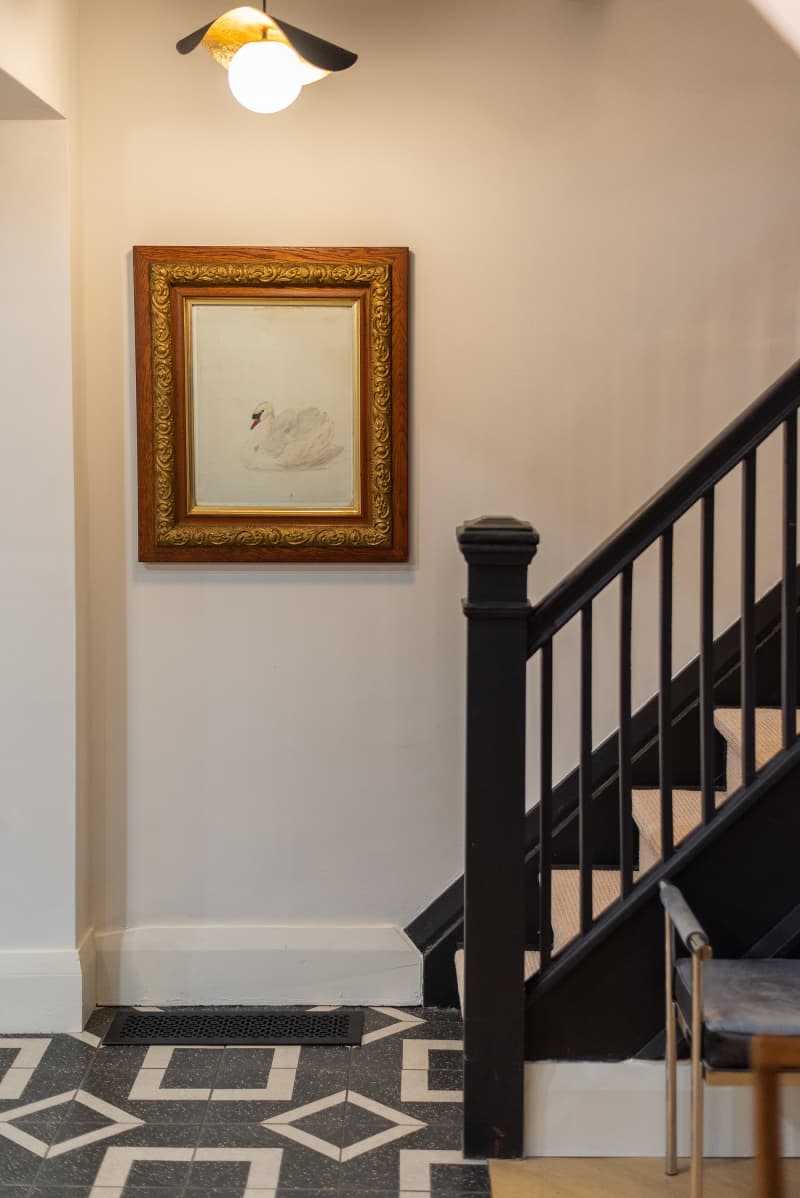 Large framed artwork near a black carpeted staircase