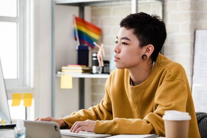 person working in an office with a pride flag on their shelf