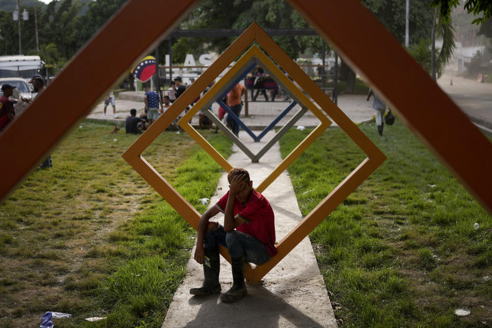 A youth sits in a park in Las Tejerias, Venezuela, Wednesday, Oct. 12, 2022, four days after the town was hit by a landslide caused by heavy rains that killed dozens. (AP Photo/Matias Delacroix)