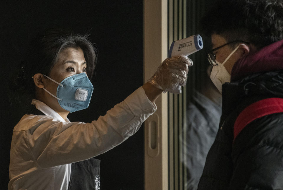 BEIJING, CHINA - JANUARY 30: A Chinese worker from Starbucks checks the temperature of a customer at Beijing Capital Airport on January 30, 2020 in Beijing, China. The number of cases of a deadly new coronavirus rose to over 7000 in mainland China Thursday as the country continued to lock down the city of Wuhan in an effort to contain the spread of the pneumonia-like disease which medicals experts have confirmed can be passed from human to human. In an unprecedented move, Chinese authorities put travel restrictions on the city which is the epicentre of the virus and neighbouring municipalities affecting tens of millions of people. The number of those who have died from the virus in China climbed to over 170 on Thursday, mostly in Hubei province, and cases have been reported in other countries including the United States, Canada, Australia, Japan, South Korea, and France. The World Health Organization  has warned all governments to be on alert, and its emergency committee is to meet later on Thursday to decide whether to declare a global health emergency. (Photo by Kevin Frayer/Getty Images)