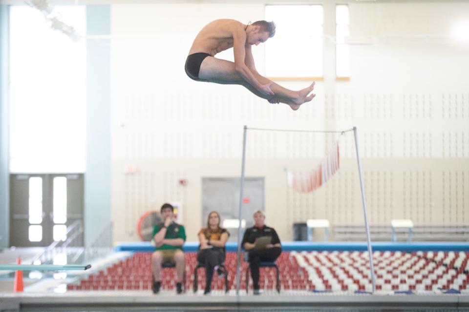 Topeka High sophomore diver Jaxon Cowdin flys high above the judges as he competes at Tuesday's Topeka West Invitational at Capitol Federal Natatorium.
