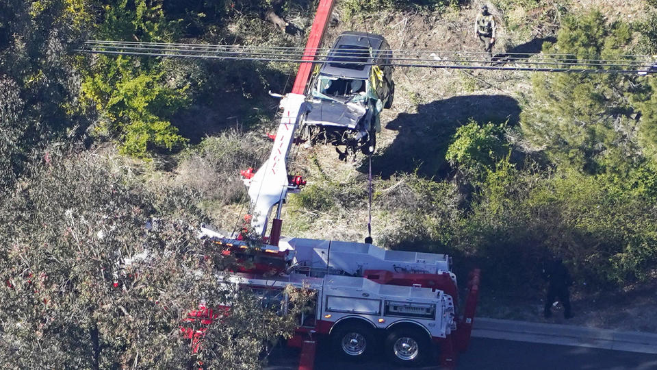 Workers, pictured here moving Tiger Woods' vehicle after his horror crash.