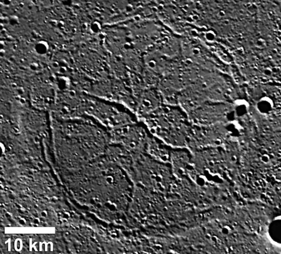 Wrinkle ridges and depressed troughs combine in this depressed crater in the Goethe basin on Mercury. The troughs, up to 2 kilometers wide, crosscut the outer ridge ring.