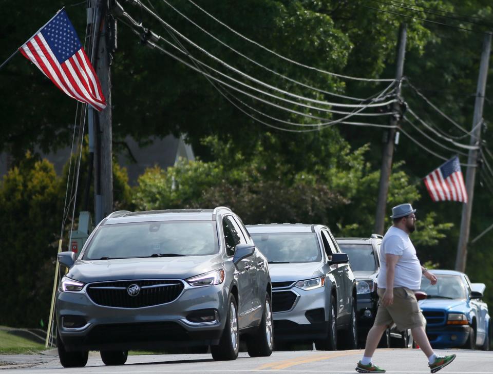 A pedestrian walks across Southwest Avenue as cars wait to enter the Tallmadge Circle.