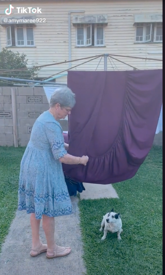 Woman showing how to fold a fitted sheet