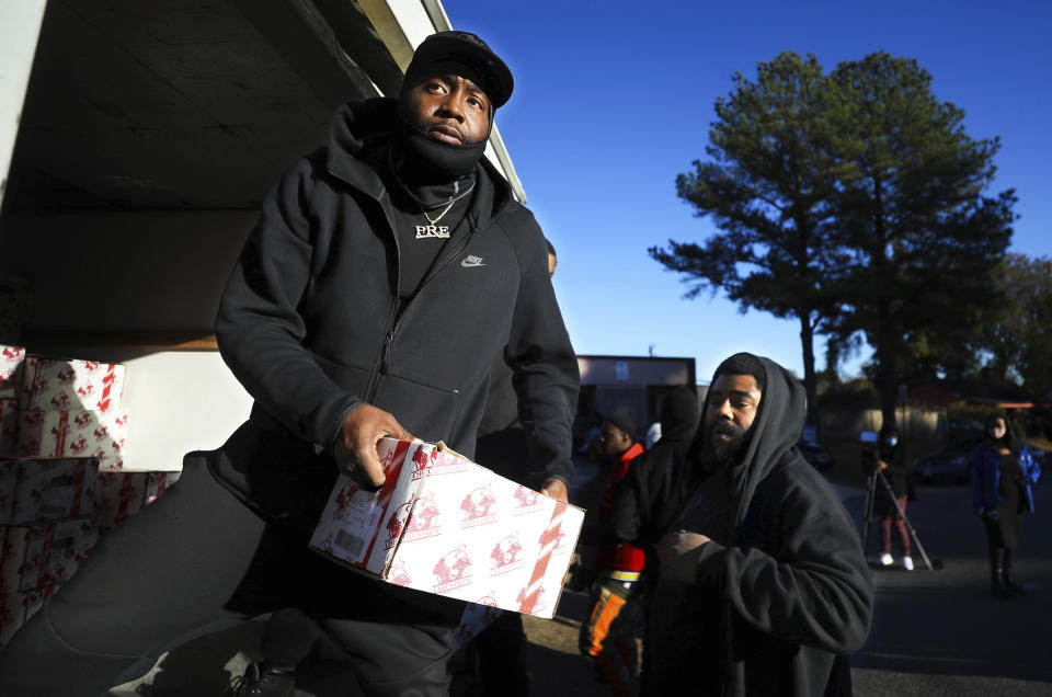 Calvin Gathings helps unload a truck full of turkeys at St. James Missionary Baptist Church in south Memphis, Tenn., Friday, Nov. 19, 2021. The event was planned by local rapper Young Dolph before he was killed two days prior. (Patrick Lantrip/Daily Memphian via AP)