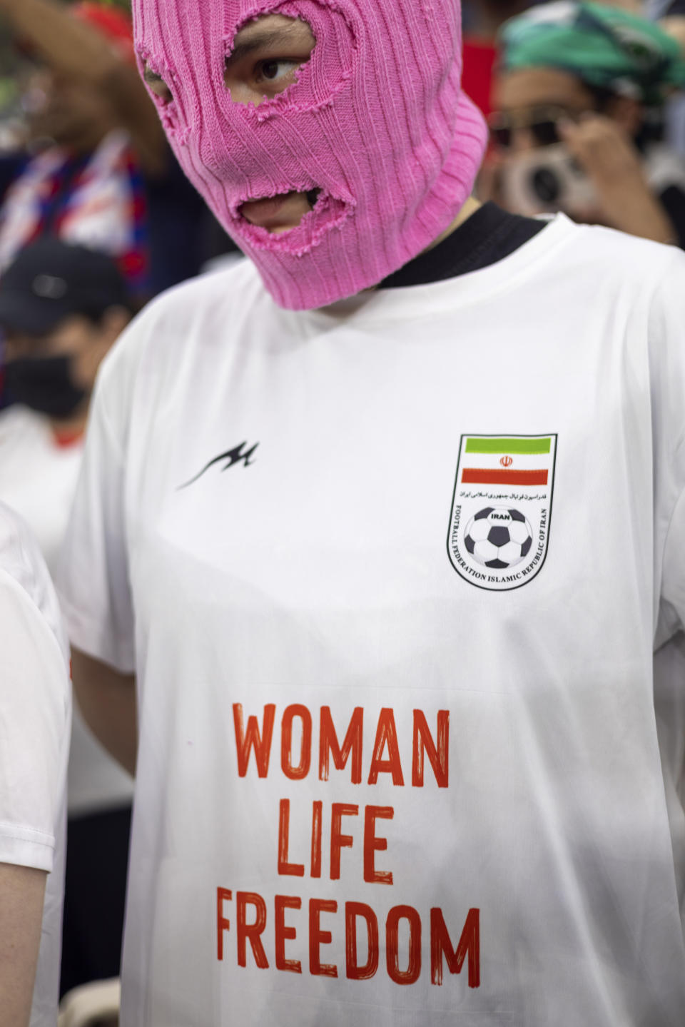 One of group of young women wearing colorful balaclavas who identified themselves as members of the Pussy Riot collective in the stands during the World Cup group B soccer match between Iran and the United States at the Al Thumama Stadium in Doha, Qatar, Tuesday, Nov. 29, 2022. (AP Photo/Ciaran Fahey)
