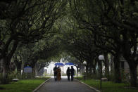 Giselle Peixoto, second left, leaves the Penitencia cemetery with her family after the inauguration of a monument to commemorate COVID-19 victims, at the Penitencia cemetery, in Rio de Janeiro, Brazil, Sunday, Sept.20, 2020. A three-ton memorial was inaugurated on Sunday inside a cemetery where many of Rio de Janeiro's COVID-19 victims have been buried. (AP Photo/Silvia Izquierdo)