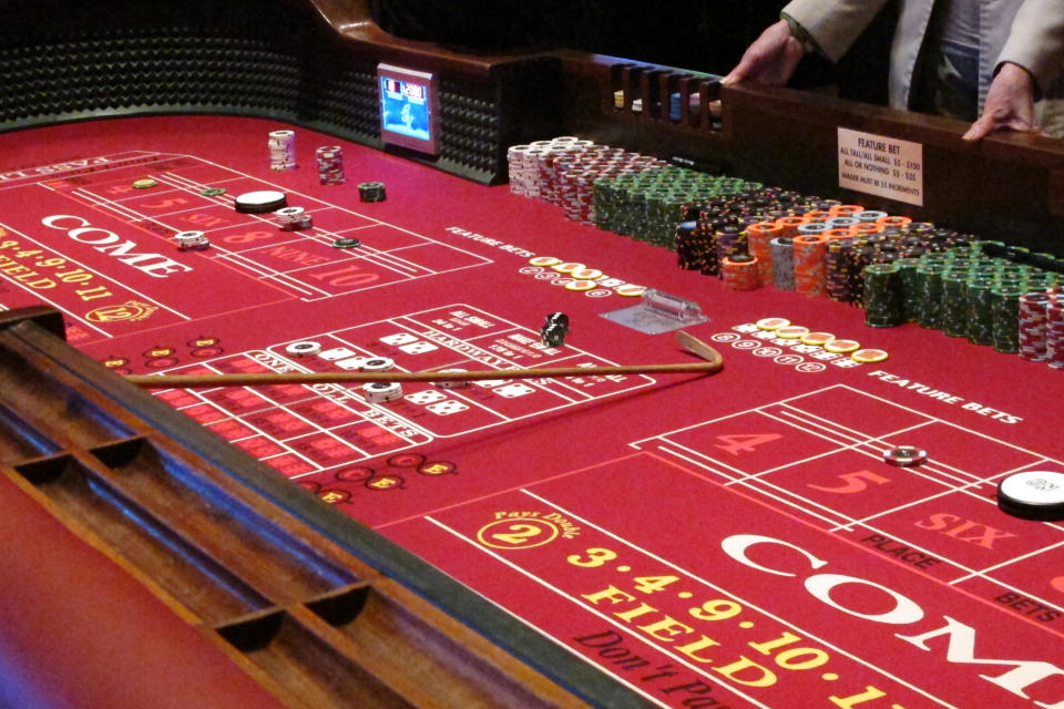 In this Feb. 22, 2019 photo, players gather around a table of craps at the Golden Nugget casino in Atlantic City N.J. Commercial casinos in 25 U.S. states won $43.6 billion from gamblers in 2019, an increase of nearly 4% from the previous year, according to a report issued late Wednesday, June 3, 2020, by The American Gaming Association, the casino industry’s national trade group. (AP Photo/Wayne Parry)