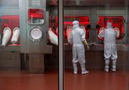 Employees operate a filling machine inside a lab at the Serum Institute of India, in Pune