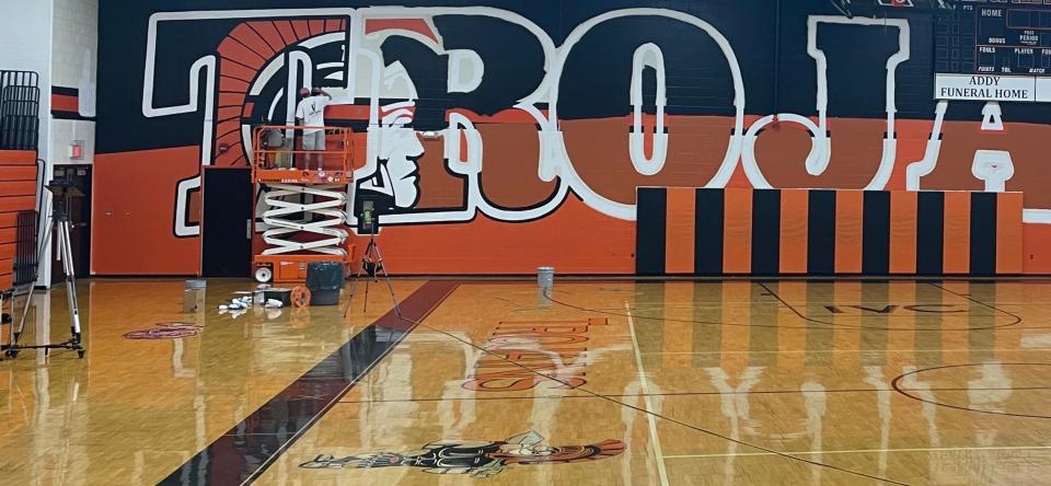 Scott Hagan, who's also known as "The Barn Artist," painted a mural at Newcomerstown High School that features 14-foot high letters and spans 100 feet.