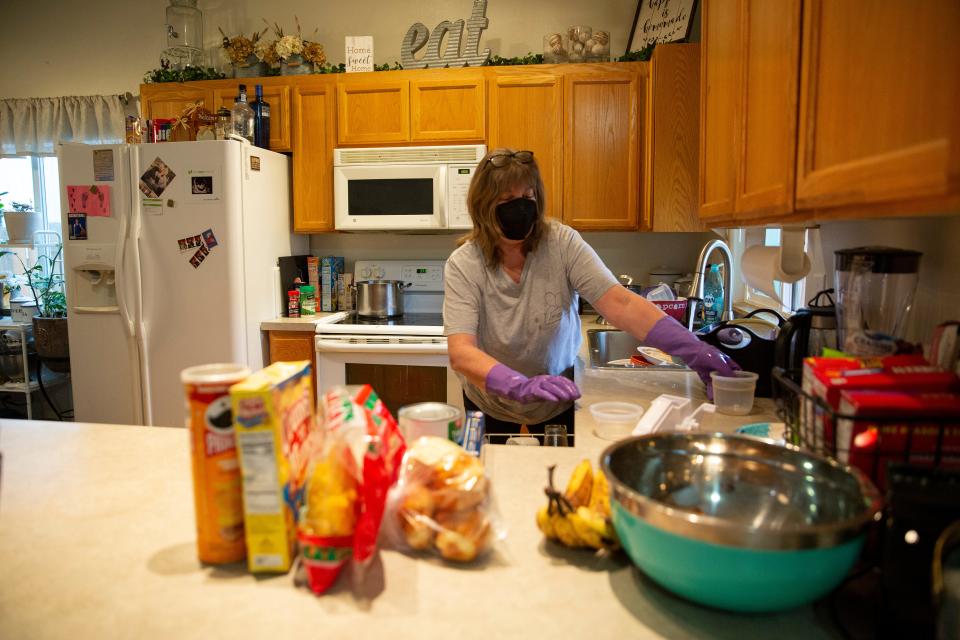 Volunteer Jacque Ihander with non-profit Michelle's Love helps clean Lisa Painter's home on Saturday in Salem.