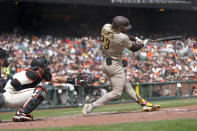 San Diego Padres' Fernando Tatis Jr., right, hits a home run in front of San Francisco Giants catcher Curt Casali during the third inning of a baseball game in San Francisco, Thursday, Sept. 16, 2021. (AP Photo/Jeff Chiu)