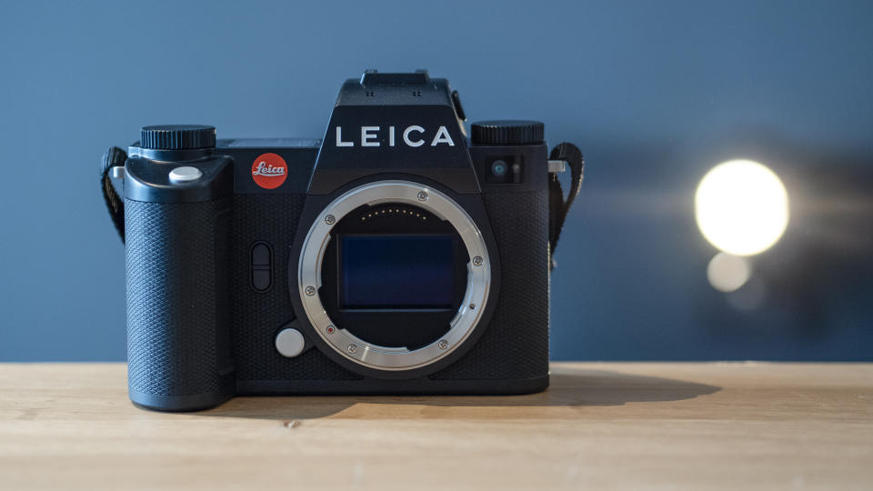 Leica SL3 camera on a wooden surface against a blue background