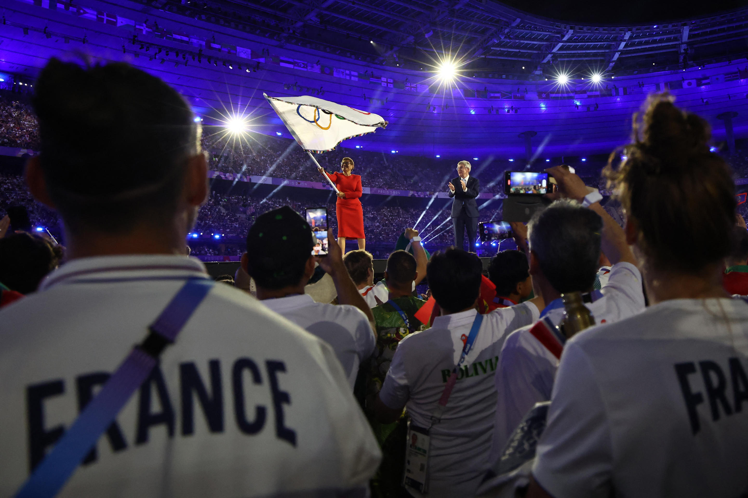 Los Angeles Mayor Karen Bass, left, waves the Olympic flag next to International Olympic Committee President Thomas Bach during the closing ceremony of the Paris 2024 Olympic Games. 