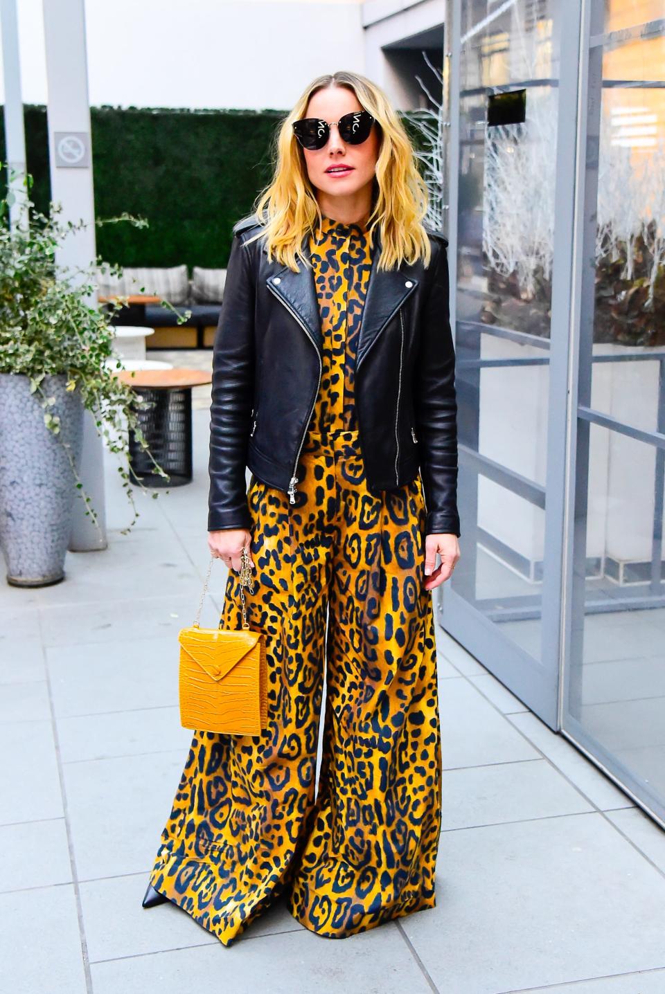 Kristen Bell in a leather jacket and leopard-print jumpsuit