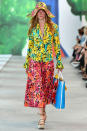 <p>A model walks the Michael Kors Spring 2019 show during New York Fashion Week wearing a colorful floral, floppy bucket hat, which matches her ensemble. (Photo: Getty Images) </p>