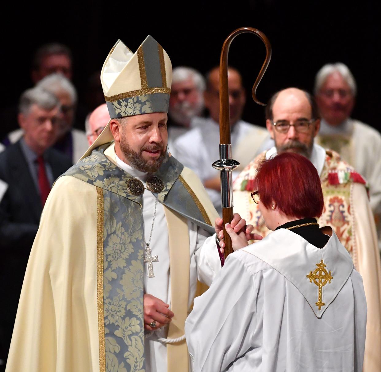 Newly ordained Bishop Rev. Dr. Douglas F. Scharf, wearing his new chasuble, Episcopal ring, and mitre, receives his crozier, a staff symbolizing his new role as chief shepherd.