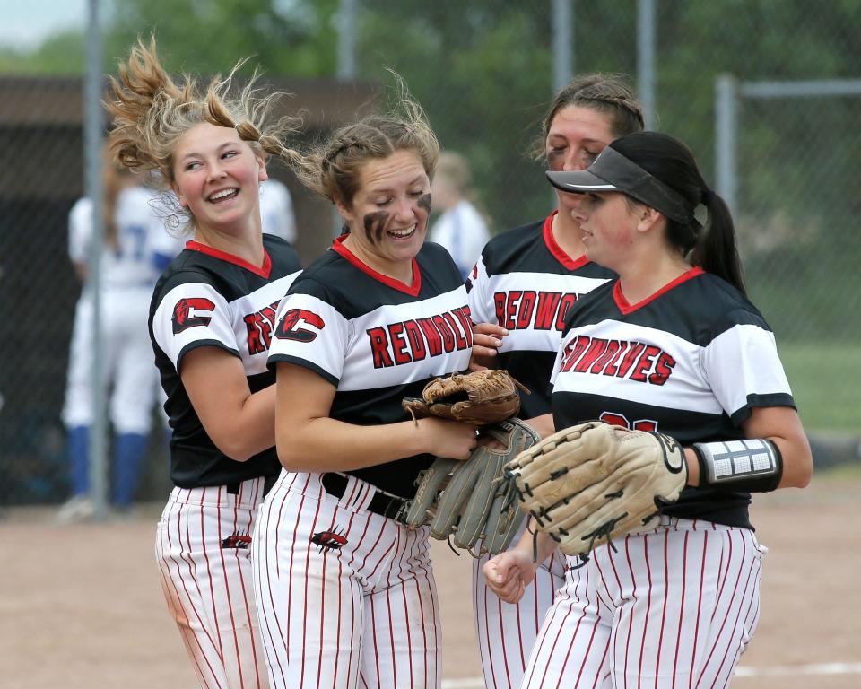 Clinton's Noelle Riley (far left), Sydney Schuler (center), Kendall Phillip (back) and Davia Welch (right) celebrate after a final out in an inning during Monday's doubleheader against Dundee.