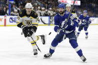 Tampa Bay Lightning right wing Nikita Kucherov (86) and Boston Bruins defenseman Zdeno Chara (33) chase a loose puck during the second period of an NHL hockey game Tuesday, March 3, 2020, in Tampa, Fla. (AP Photo/Chris O'Meara)