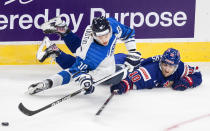 United States' Matty Beniers (10) and Finland's Kasper Puutio (10) battle for the puck during first period of an exhibition game in Edmonton, Alberta, Thursday, Dec. 23, 2021, before the IIHF World Junior Hockey Championship tournament. (Jason Franson/The Canadian Press via AP)