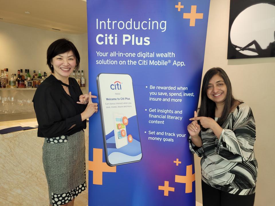 Image showing two ladies in front of a poster introducing the new Citibank offering, Citi Plus. 