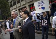 A supporter of New England Patriots quarterback Tom Brady holds up a sign as television reporters speak on camera outside the National Football League (NFL) headquarters offices in the Manhattan borough of New York City, June 23, 2015. Brady's appeal of his four-game NFL suspension for participating in a scheme to deflate footballs during last season's playoffs begins Tuesday at NFL headquarters in New York. REUTERS/Mike Segar TPX IMAGES OF THE DAY