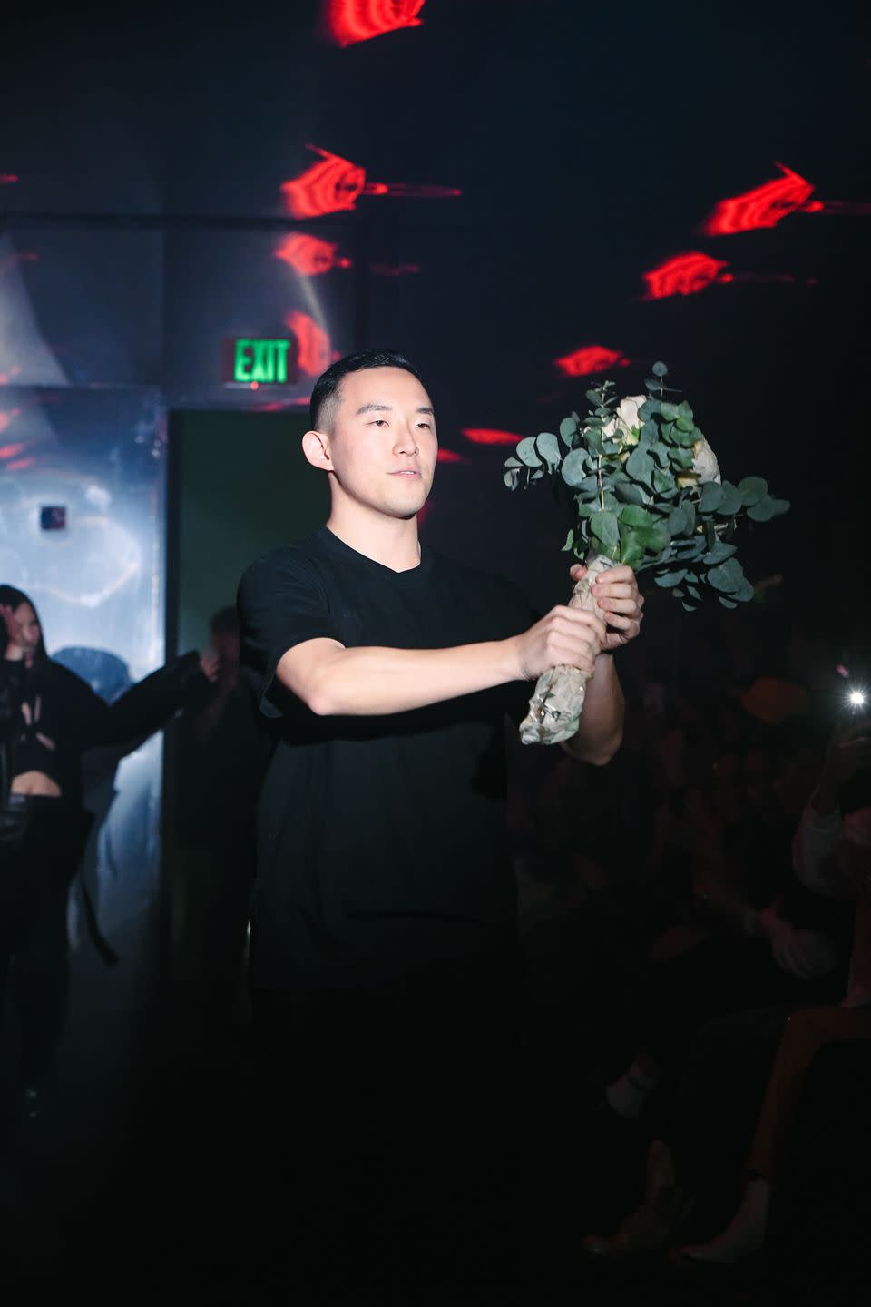 sundae school designer dae lim with a bouquet at a fashion show