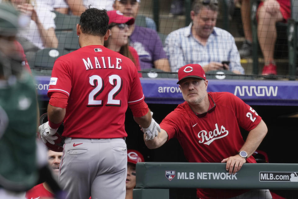 Cincinnati Reds manager David Bell, right, congratulates Luke Maile as he returns to the dugout after hitting a solo home run off Colorado Rockies starting pitcher Austin Gomber in the fifth inning of a baseball game Wednesday, May 17, 2023, in Denver. (AP Photo/David Zalubowski)