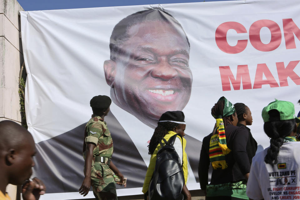 A soldier looks at a portrait of Zimbabwean President Emmerson Mnangagwa at the venue of his inauguration in Harare, Sunday, Aug. 26, 2018. This is the second swearing-in of Mnangagwa in just nine months as a country once jubilant over the fall of longtime leader Robert Mugabe is now more subdued after the reemergence of harassment of the opposition.(AP Photo/Tsvangirayi Mukwazhi)