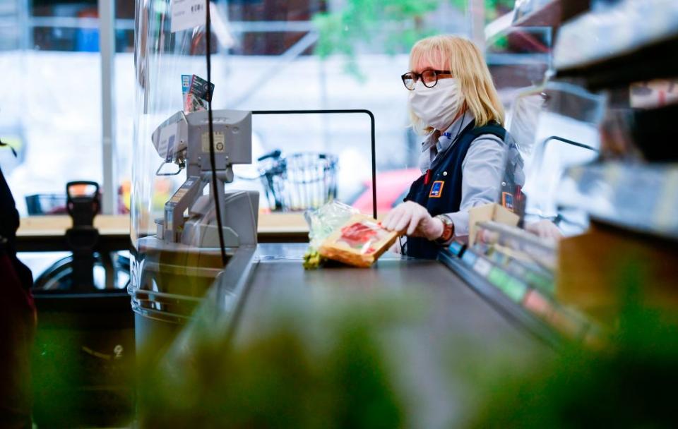 A cashier scans groceries in Aldi. 