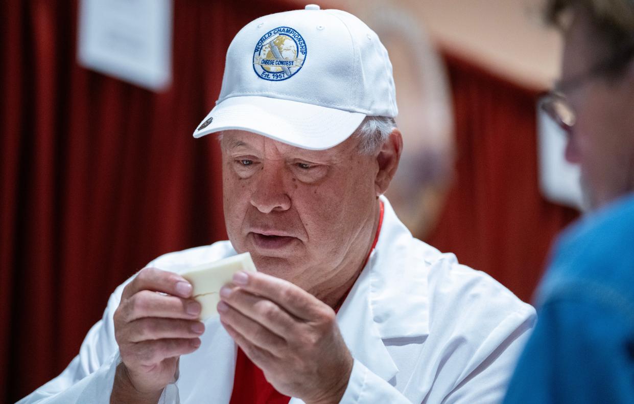 Dean Sommer, with the Center for Dairy Research in Madison, examines an entry at the World Cheese Championships on Tuesday. Sommer is among an international panel of judges evaluating 3,302 entries at the competition, which takes place every other year.