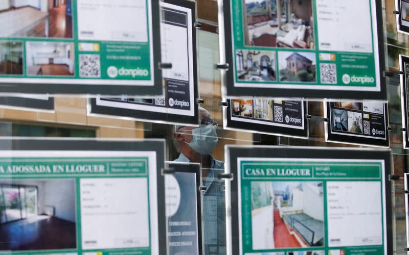 FILE PHOTO: Man looks in window of real estate agency office in El Masnou