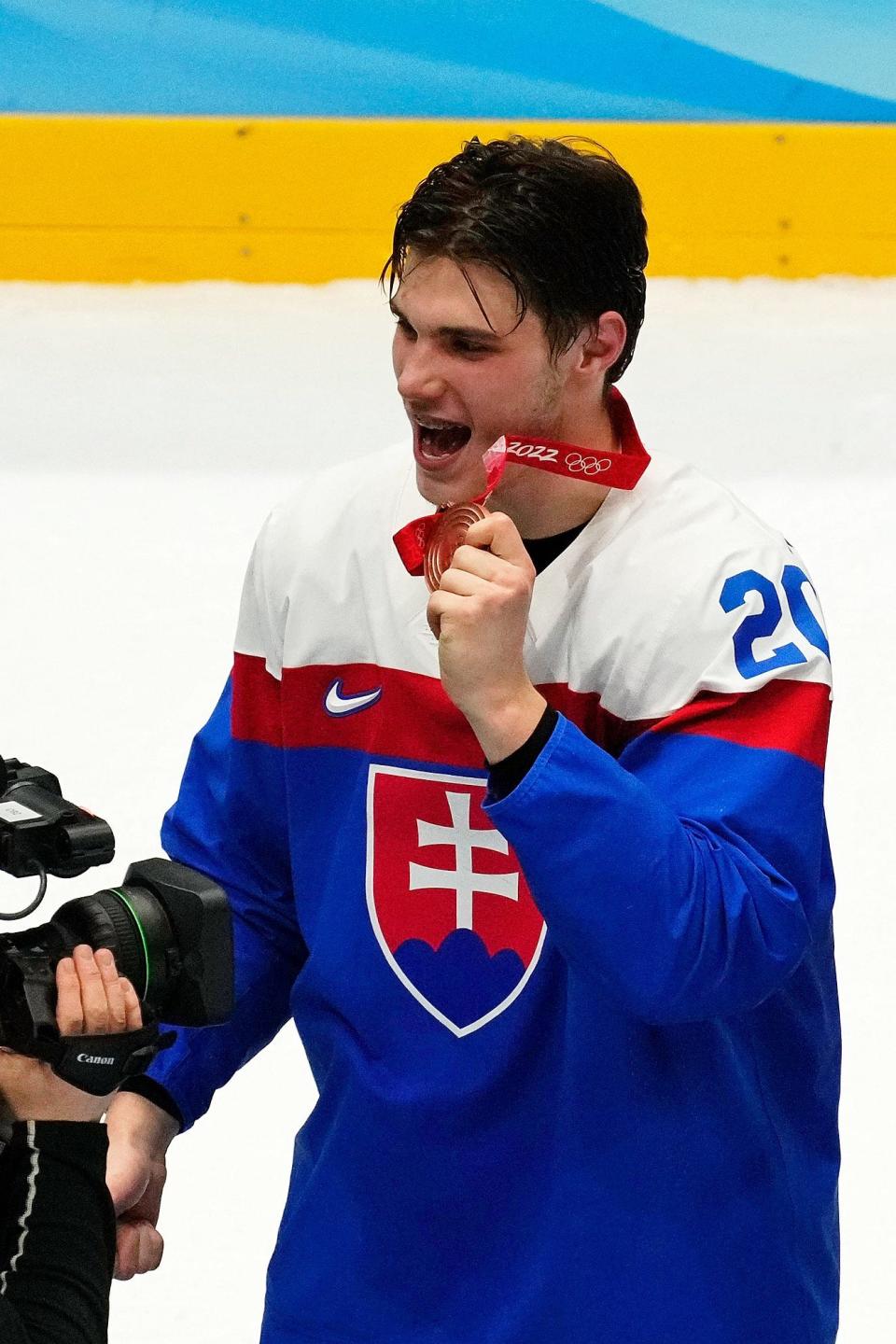 Team Slovakia forward Juraj Slafkovsky (20) celebrates winning the bronze medal at the Beijing Olympics.