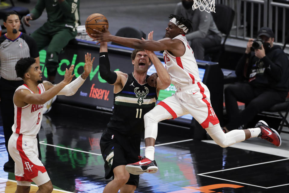 Milwaukee Bucks' Brook Lopez (11) is fouled by Houston Rockets' Danuel House Jr. during the first half of an NBA basketball game Friday, May 7, 2021, in Milwaukee. (AP Photo/Aaron Gash)