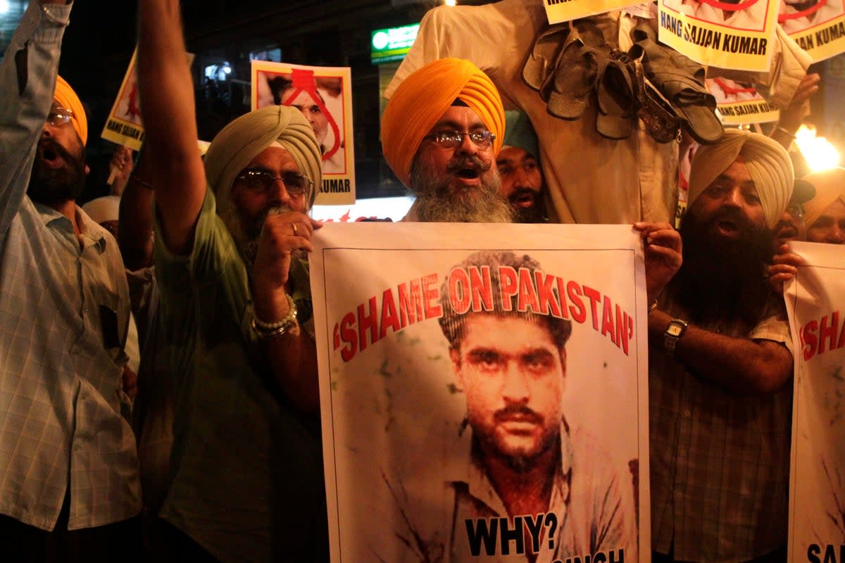 Indian Sikhs shout slogans against Pakistan as they display photographs of Sarabjit Singh, a convicted Indian spy who died from a head injury after two inmates attacked him with a brick in a Lahore jail (AP)