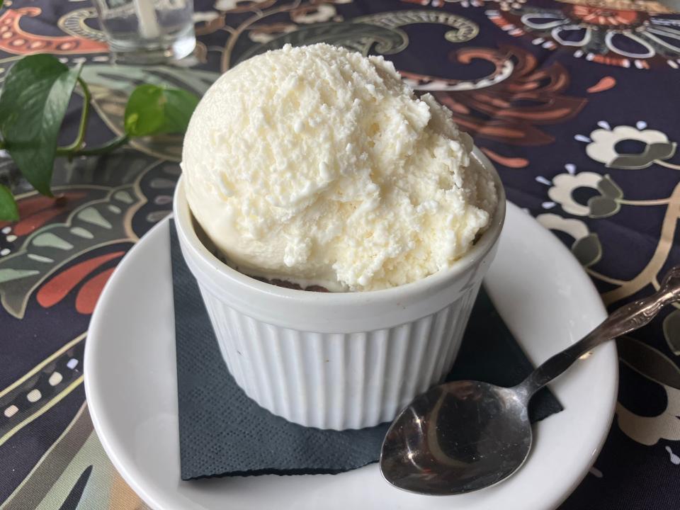 An ooey gooey flourless chocolate strawberry cake with a hefty helping of vanilla ice cream atop it.