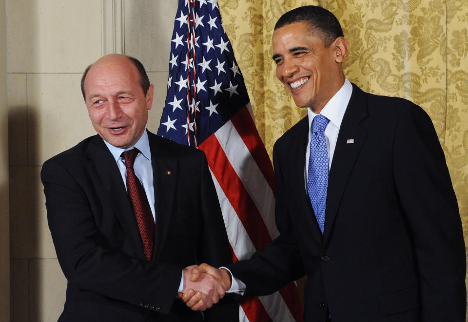 U.S. President Barack Obama (R) greets Romania's President Traian Basescu before a dinner at the U.S. Ambassador's residence in Prague on April 8, 2010.